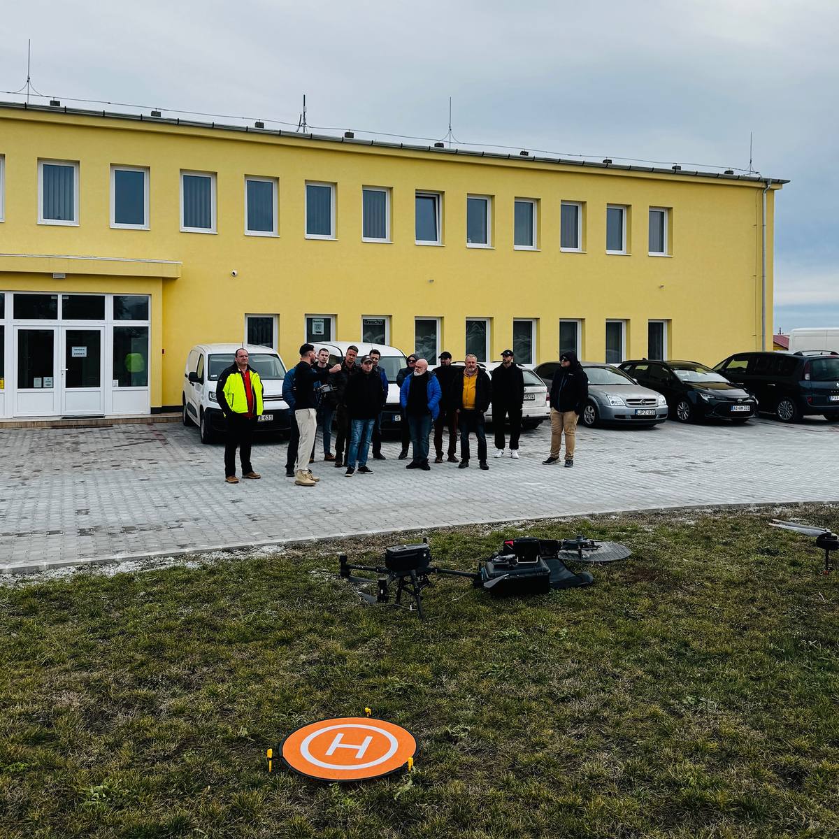 A képzési csoport a helyszín épülete előtt, drónokkal