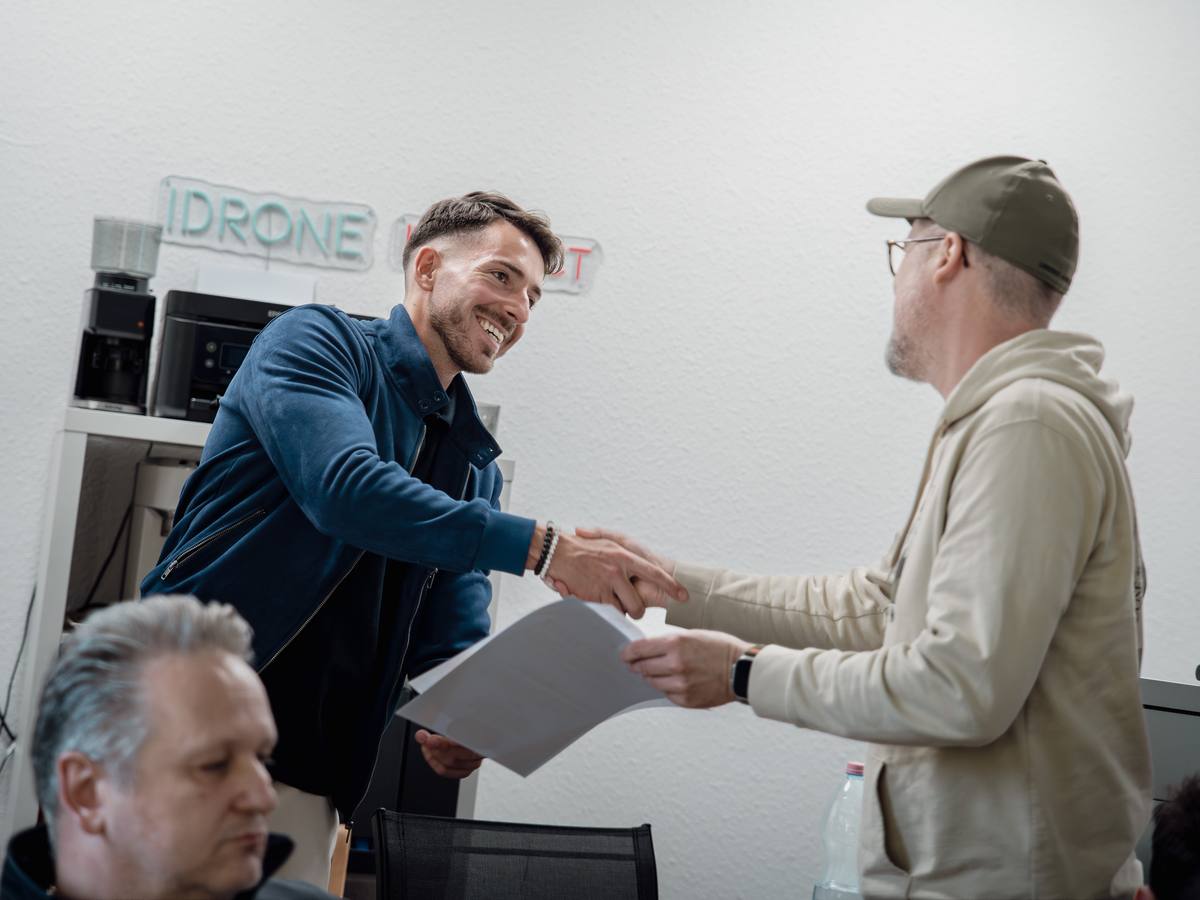 Oktató kézfogással adja át a tanúsítványt egy résztvevőnek